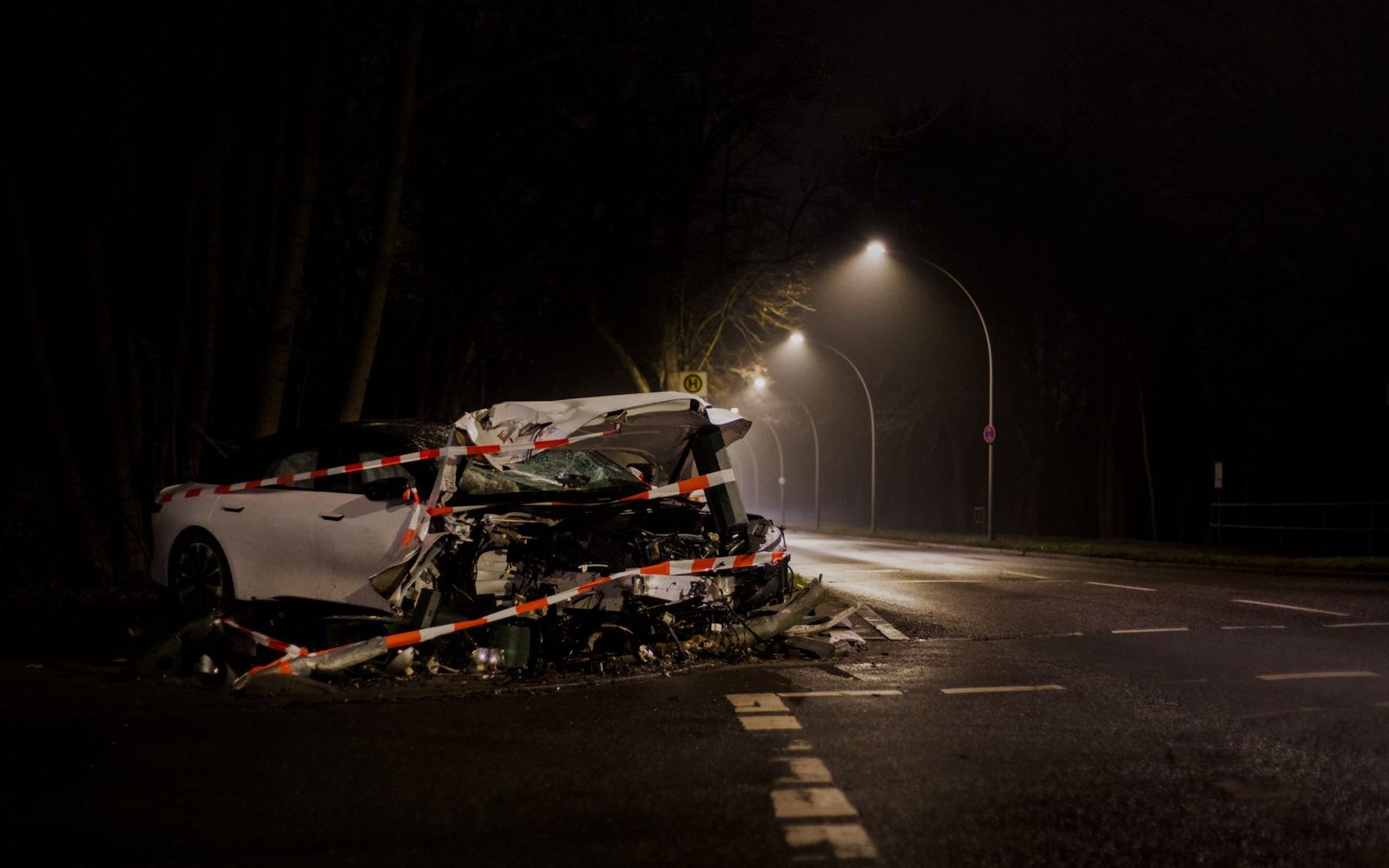 Auto destrozado tras accidente nocturno en calle oscura.