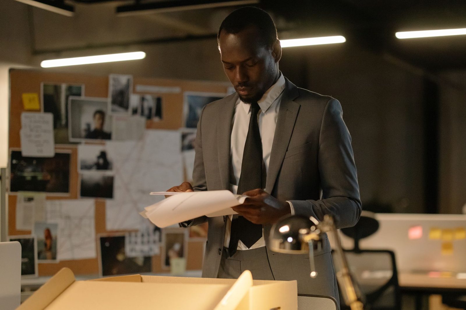 Detective reviewing evidence files at desk in office.