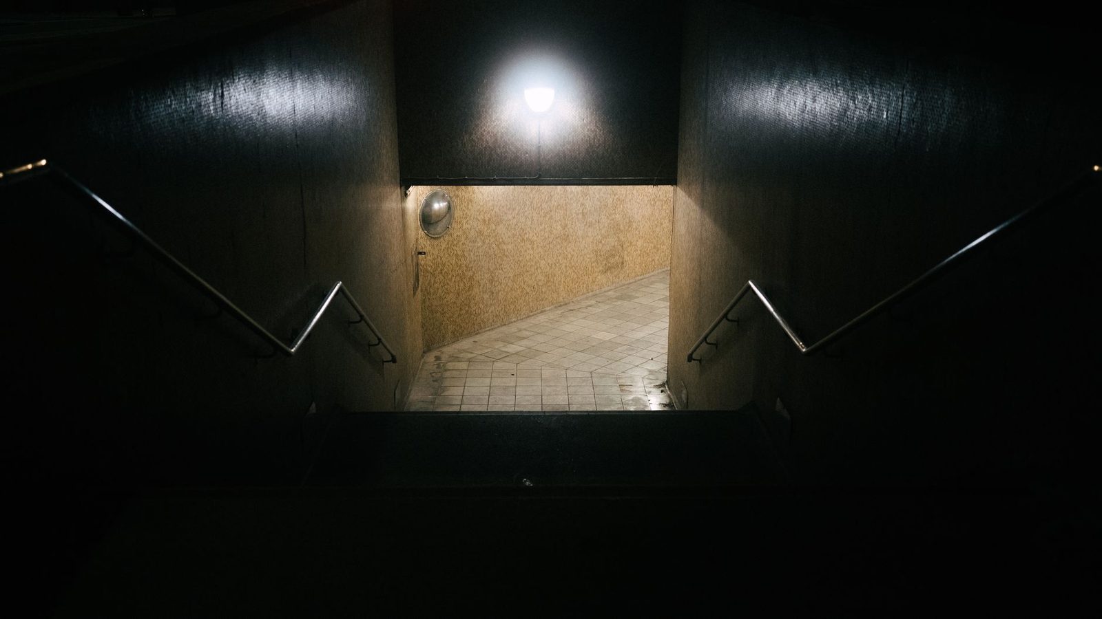 Dimly lit underground staircase in apartment building.