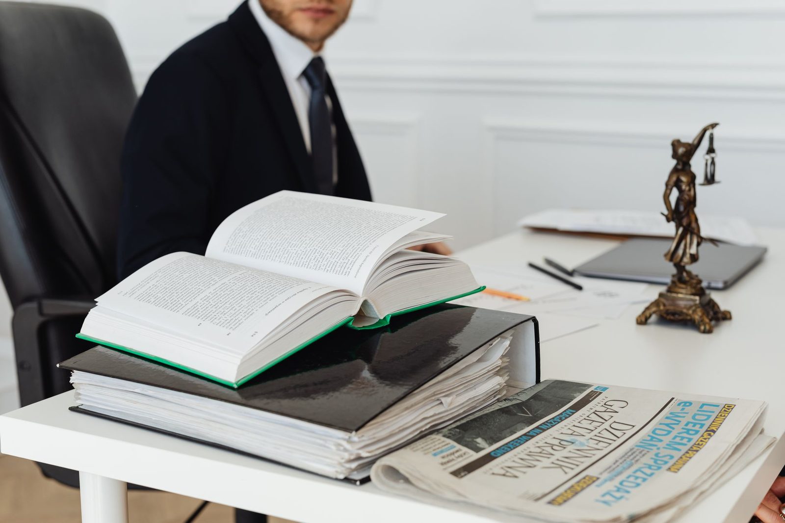 Lawyer at desk with legal books and documents in professional office setting.