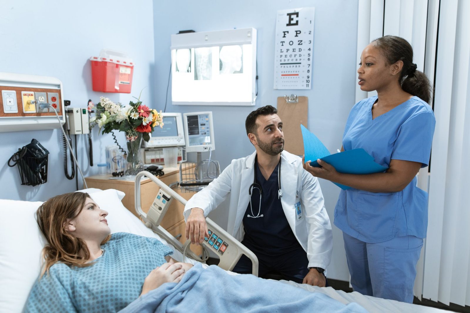 Medical team reviewing patient care in hospital room.