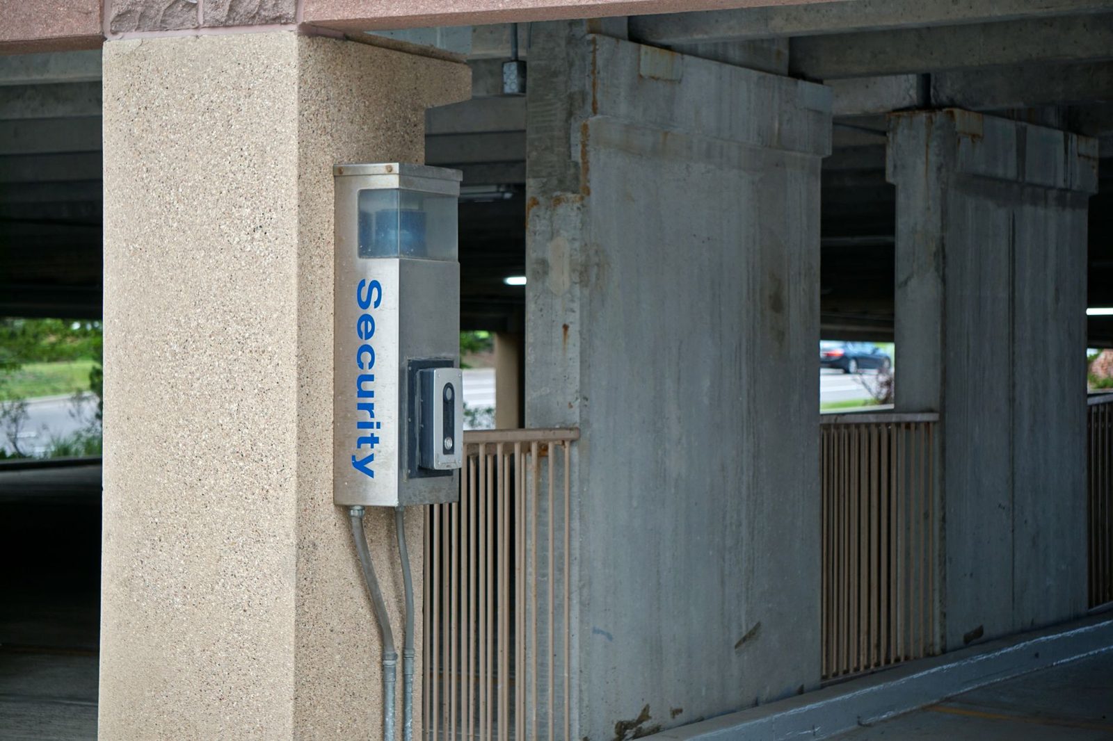 Security camera mounted on parking garage ceiling for surveillance and safety monitoring.