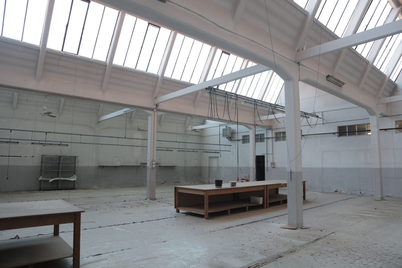 Almacén moderno con piso de concreto y vigas metálicas en edificio industrial.