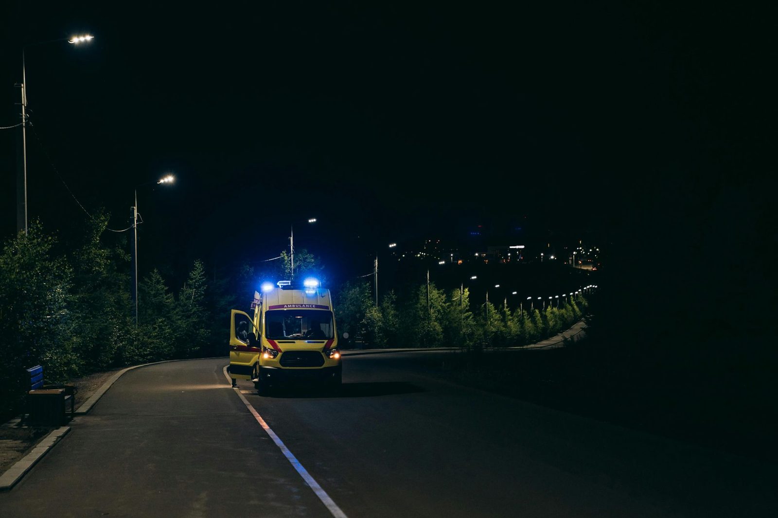 Ambulancia con luces intermitentes en una carretera rural de noche, atendiendo un accidente de tráfico en Georgia.