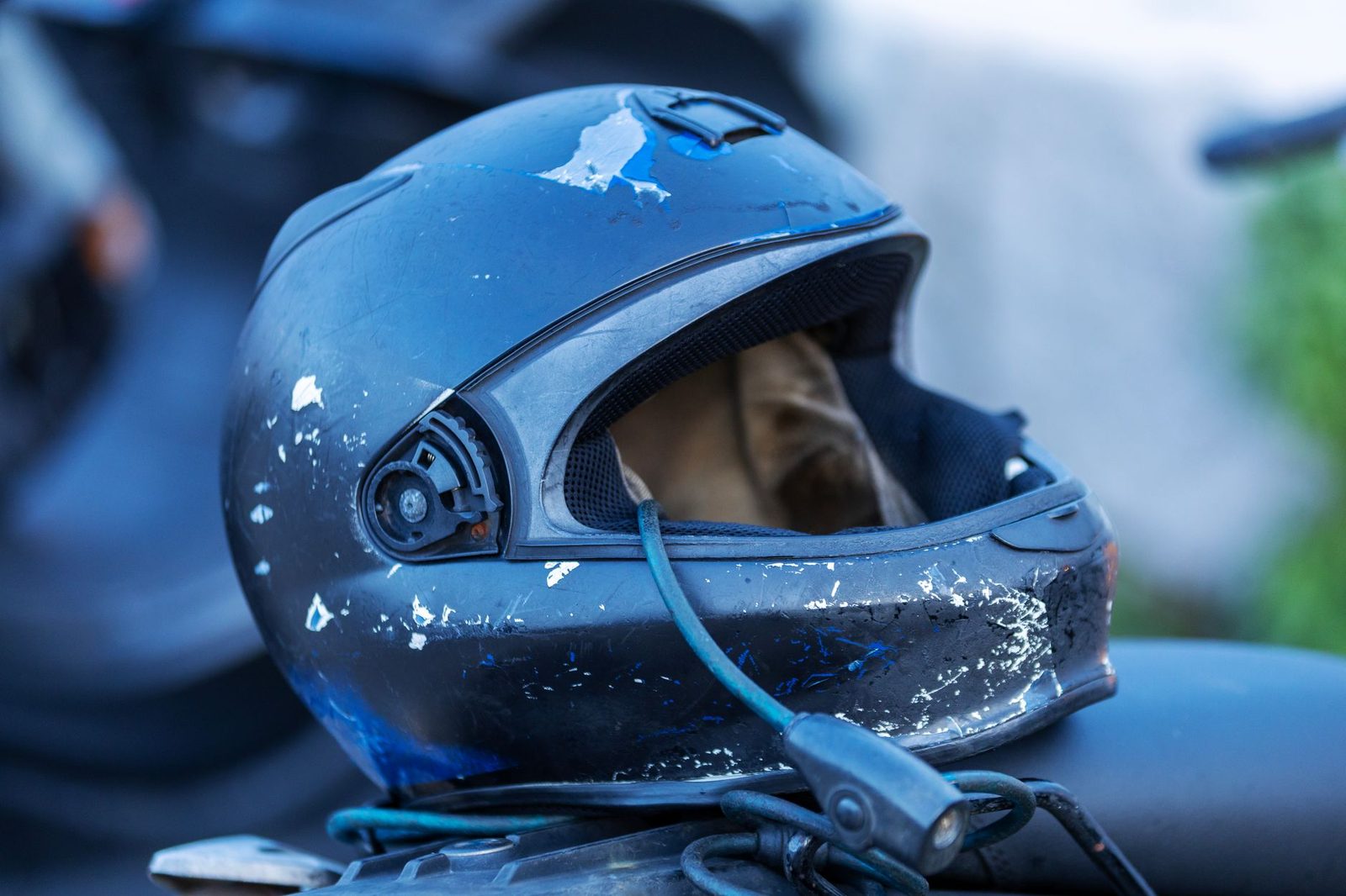 Casco de moto rayado y desgastado con una superficie exterior muy castigada.