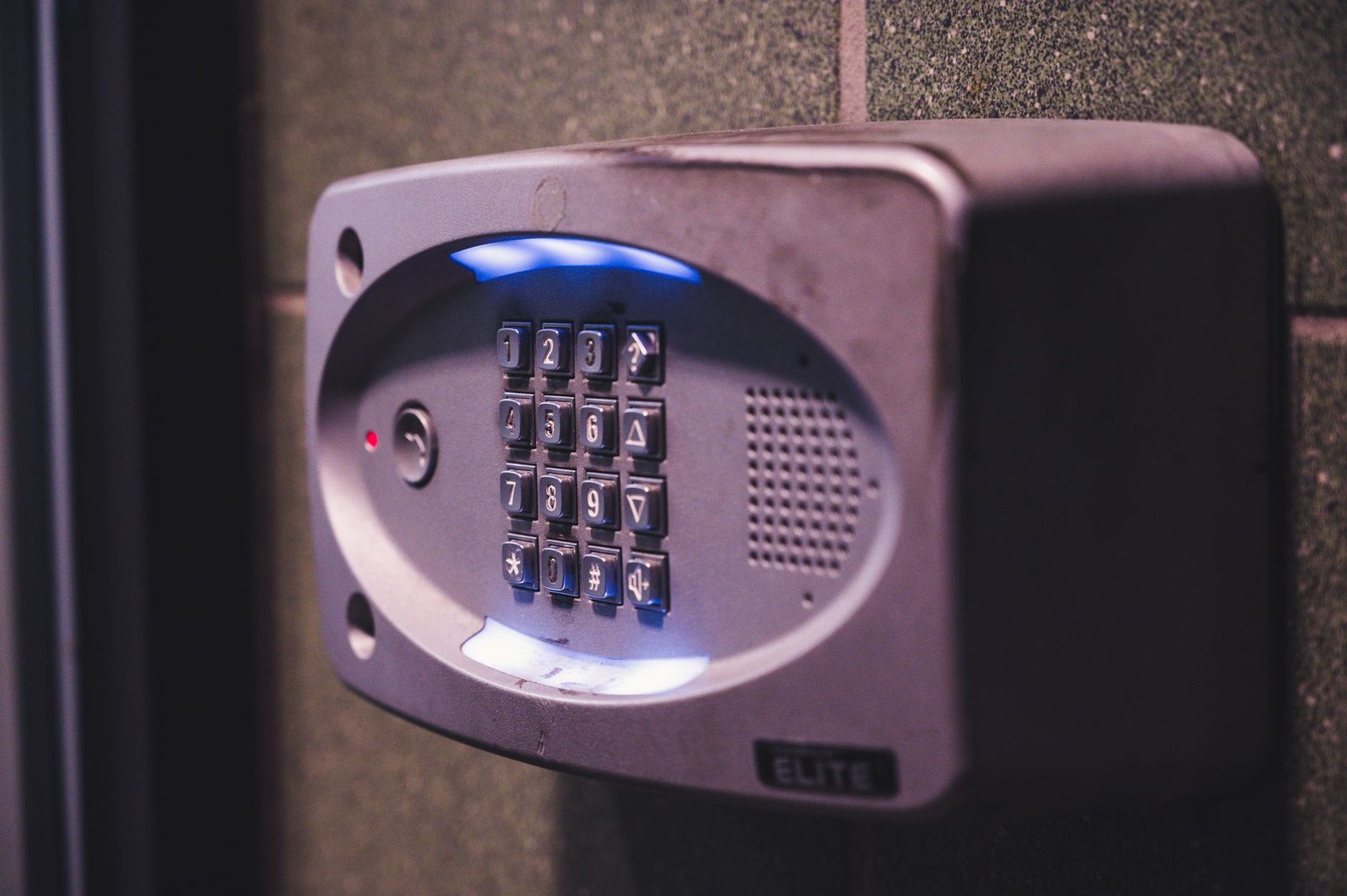 Primer plano de un teclado de seguridad iluminado montado en una pared.