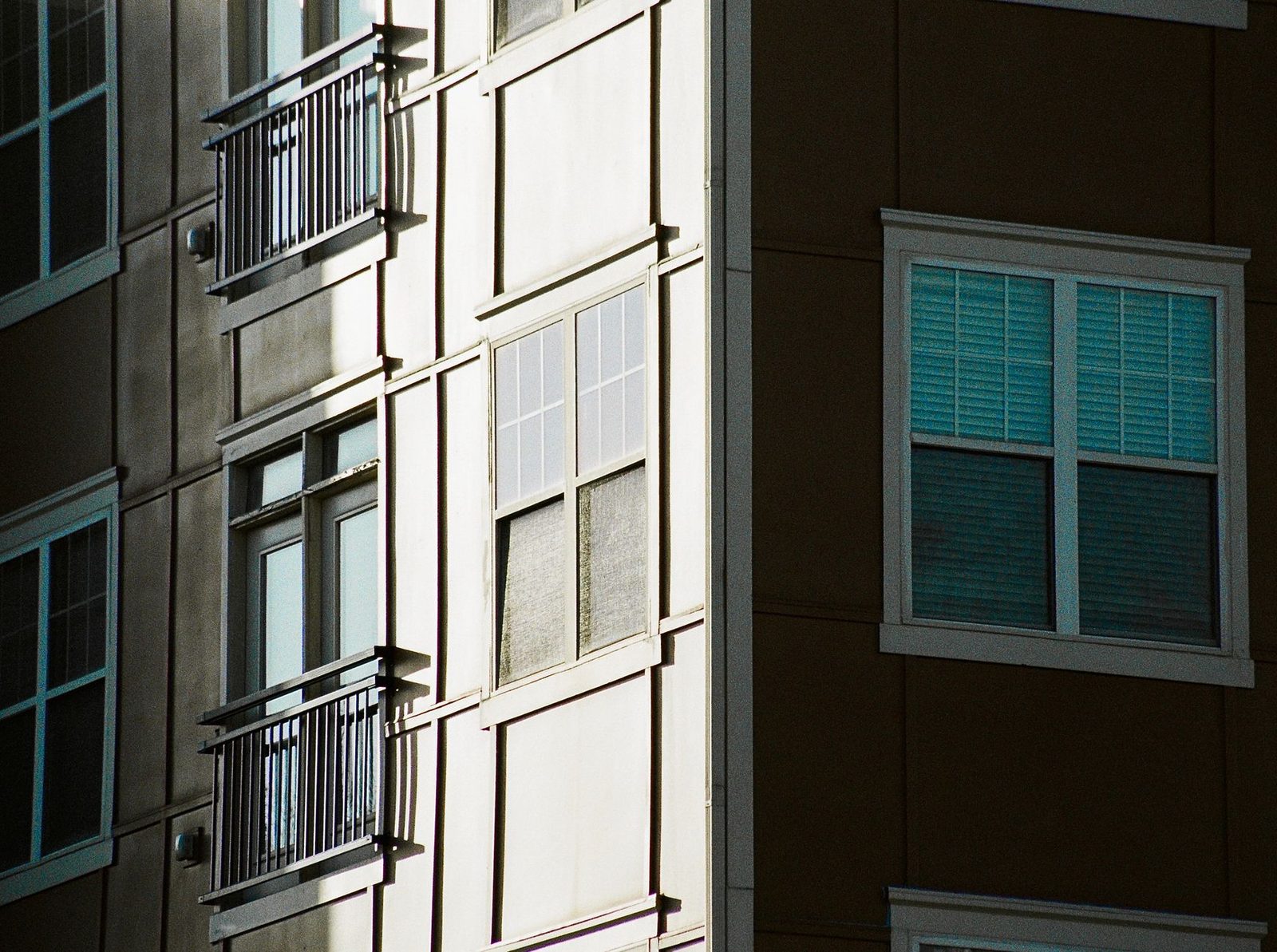 Edificio de apartamentos moderno con fachada de vidrio y ladrillo bajo luz solar en Kennesaw, Georgia.