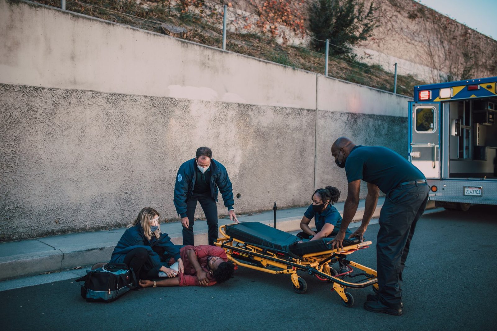 Equipo de emergencia asistiendo a persona lesionada en la calle con camilla.