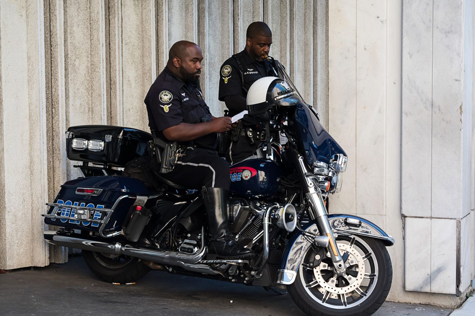 Police officers ride a motorcycle down a city street in Atlanta.