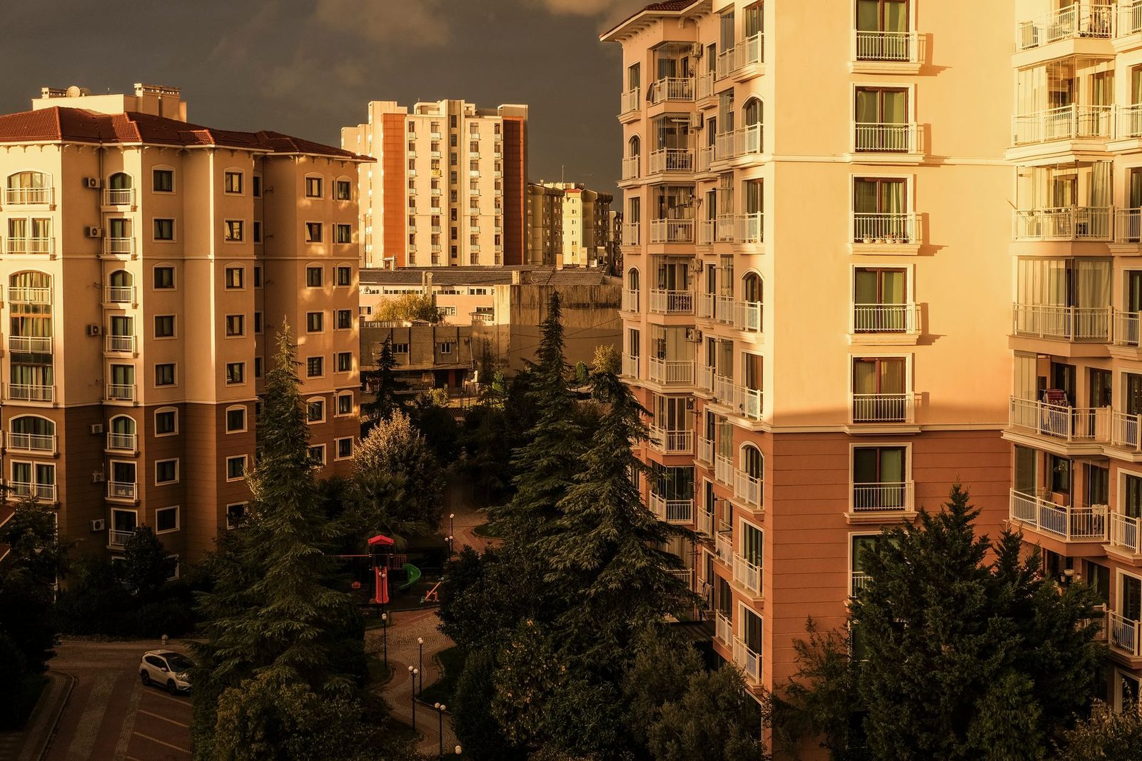 Scenic view of İstanbul apartment buildings at golden hour, featuring trees and cityscape.