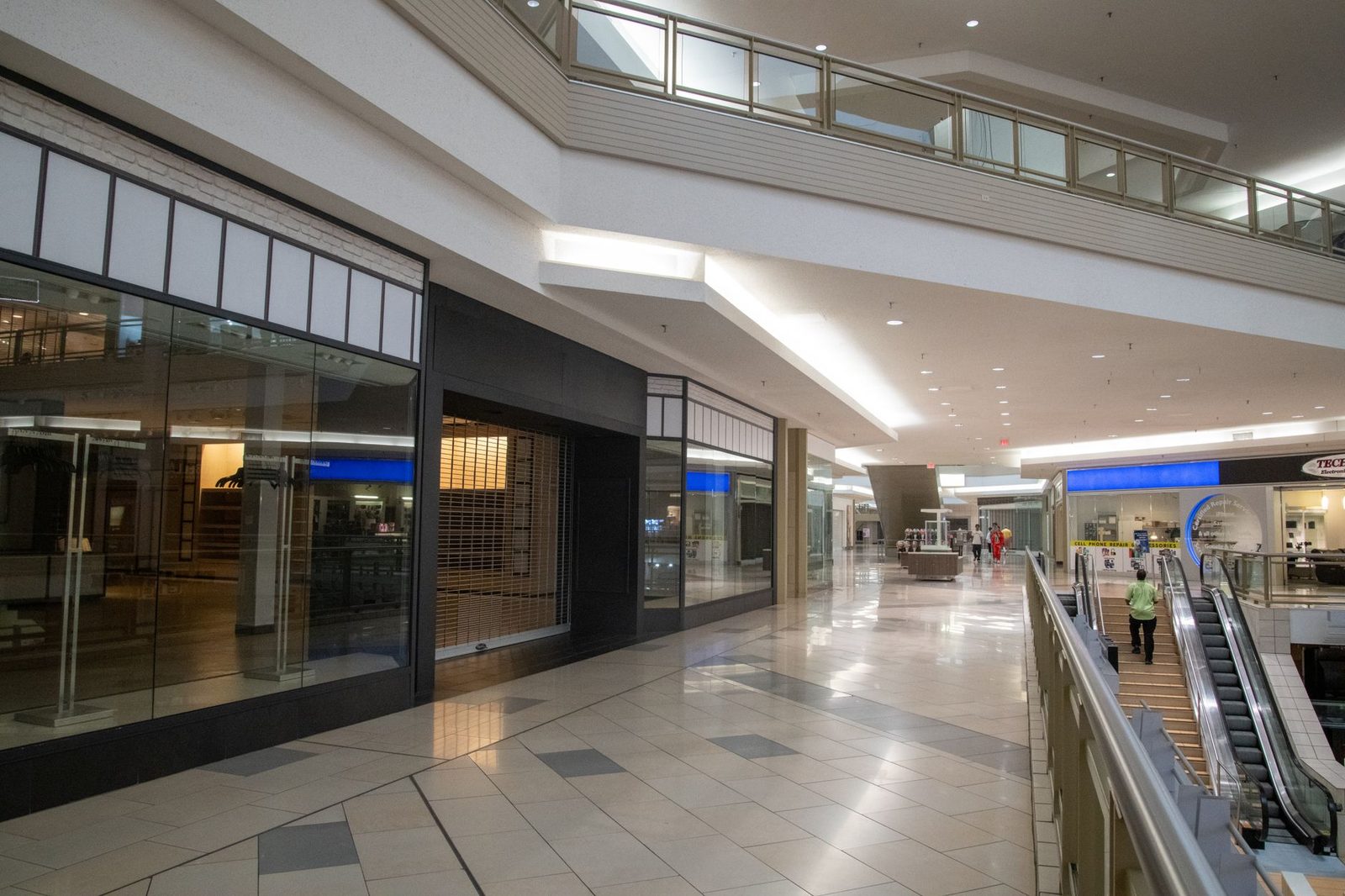 Spacious contemporary mall interior with closed storefronts and an escalator.