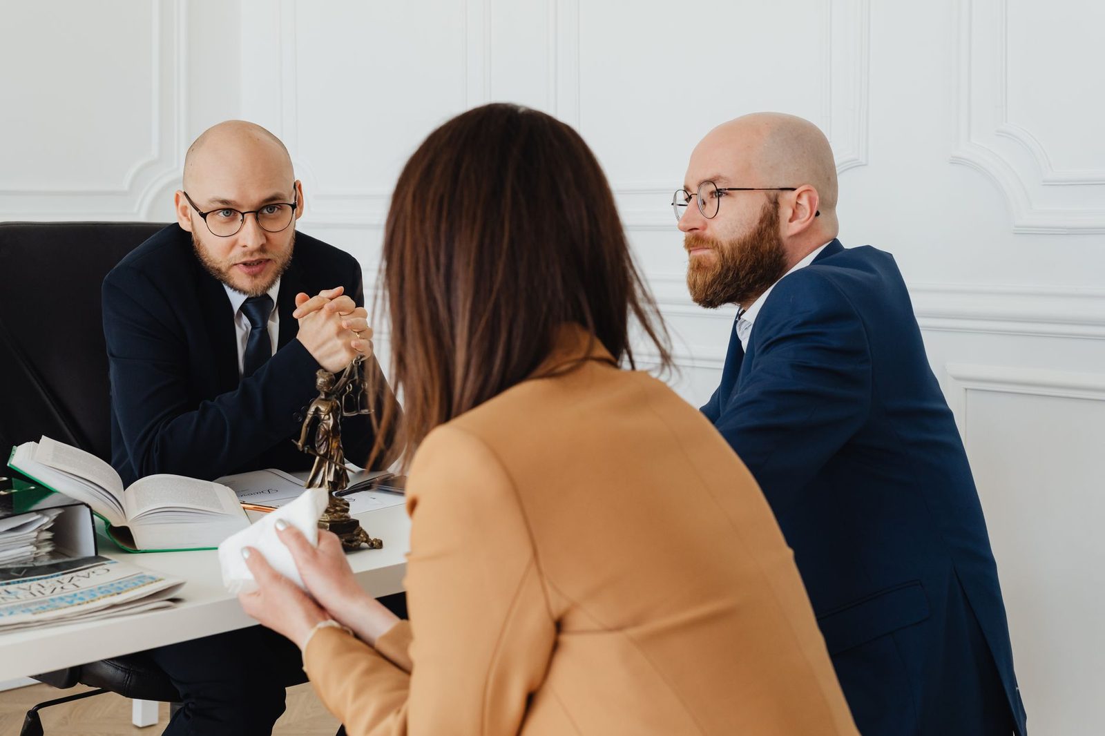 Two lawyers discuss legal documents at a table in a modern office.