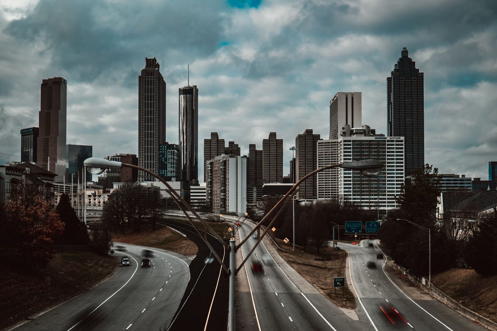 Vista dramática del horizonte de Atlanta bajo nubes grises sobre calles urbanas.
