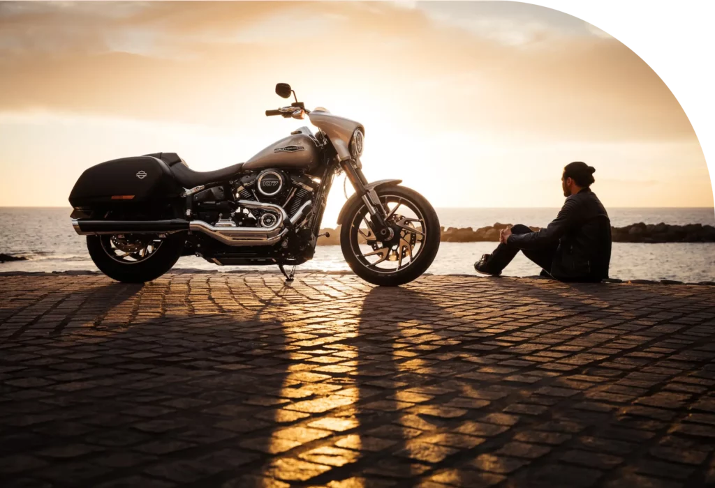 Man sitting on ground beside parked silver bike | Slam Dunk Attorney